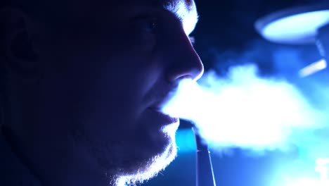 man smoking hookah in nightclub