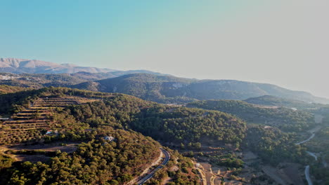 breathtaking aerial view of lush hills and winding roads during sunset