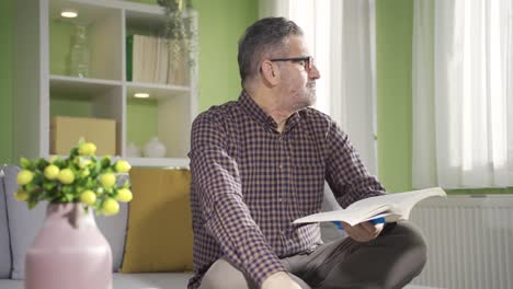 el anciano está leyendo un libro en su cómodo y fresco hogar durante el día.