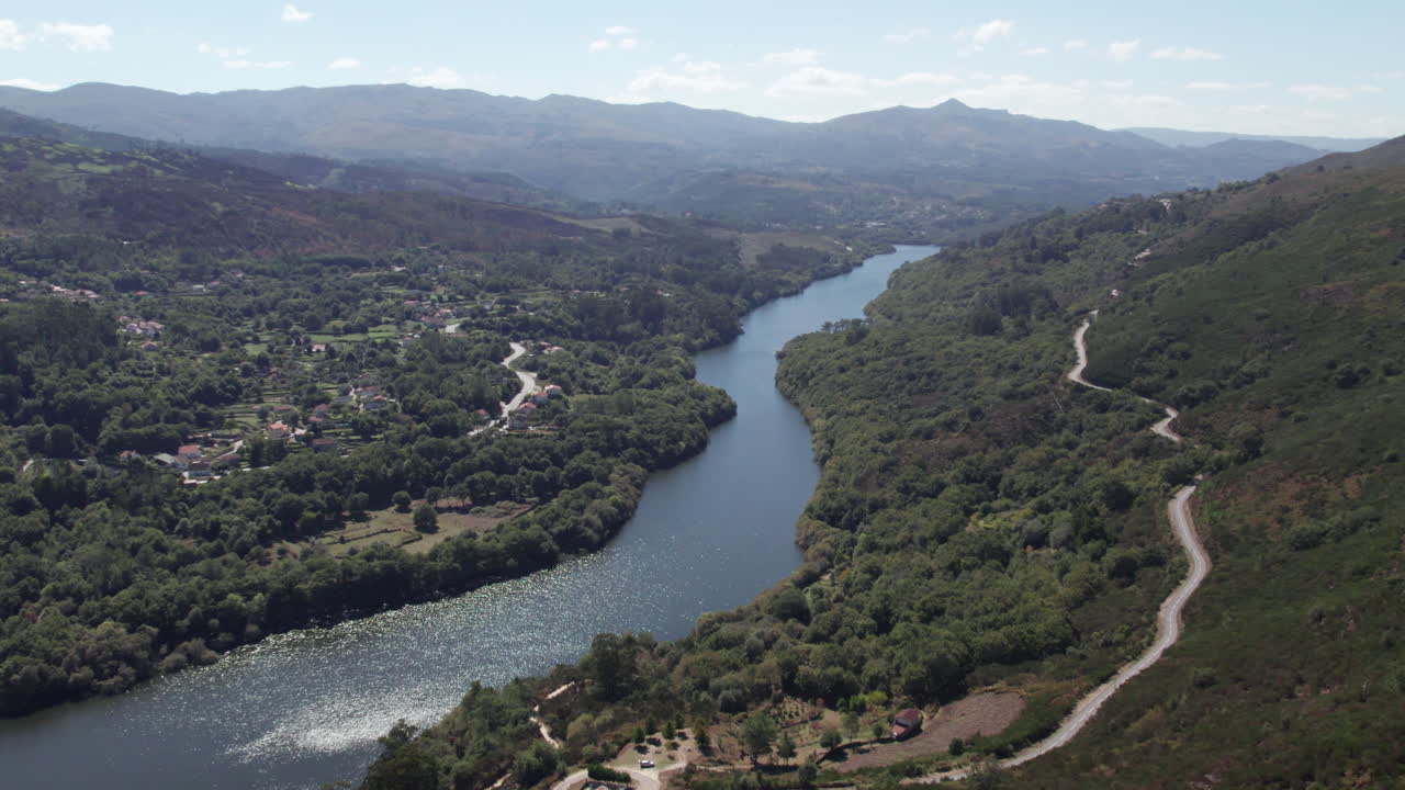 Ripresa aerea panoramica di un fiume calmo che scorre tra le montagne nel Parco Nazionale di Peneda in Portogallo.