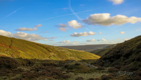 Stunning-timelapse-of-a-lush-green-valley-at-sunset-,-with-fluffy-white-clouds-and-a-brilliant-blue-sky,-scene-shot-up-at-holme-moss-summit