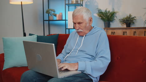 Overjoyed-senior-man-working-on-laptop-celebrate-success-win-money-in-lottery-get-online-good-news