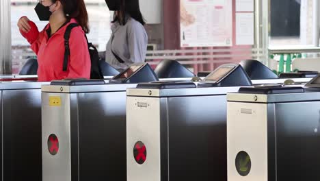 person walking through automatic ticket gates at station