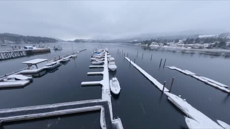 Overcast-Winter-Skies-on-a-Snow-Covered-Marina-in-Sechelt-Inlet-British-Columbia-Canada---Fast-Moving-Forward-Panning-Drone-Shot-1080p-60-frames-per-second