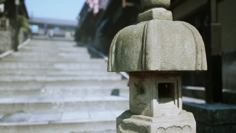 a close-up of a stone lantern on a stone pathway in a japanese garden