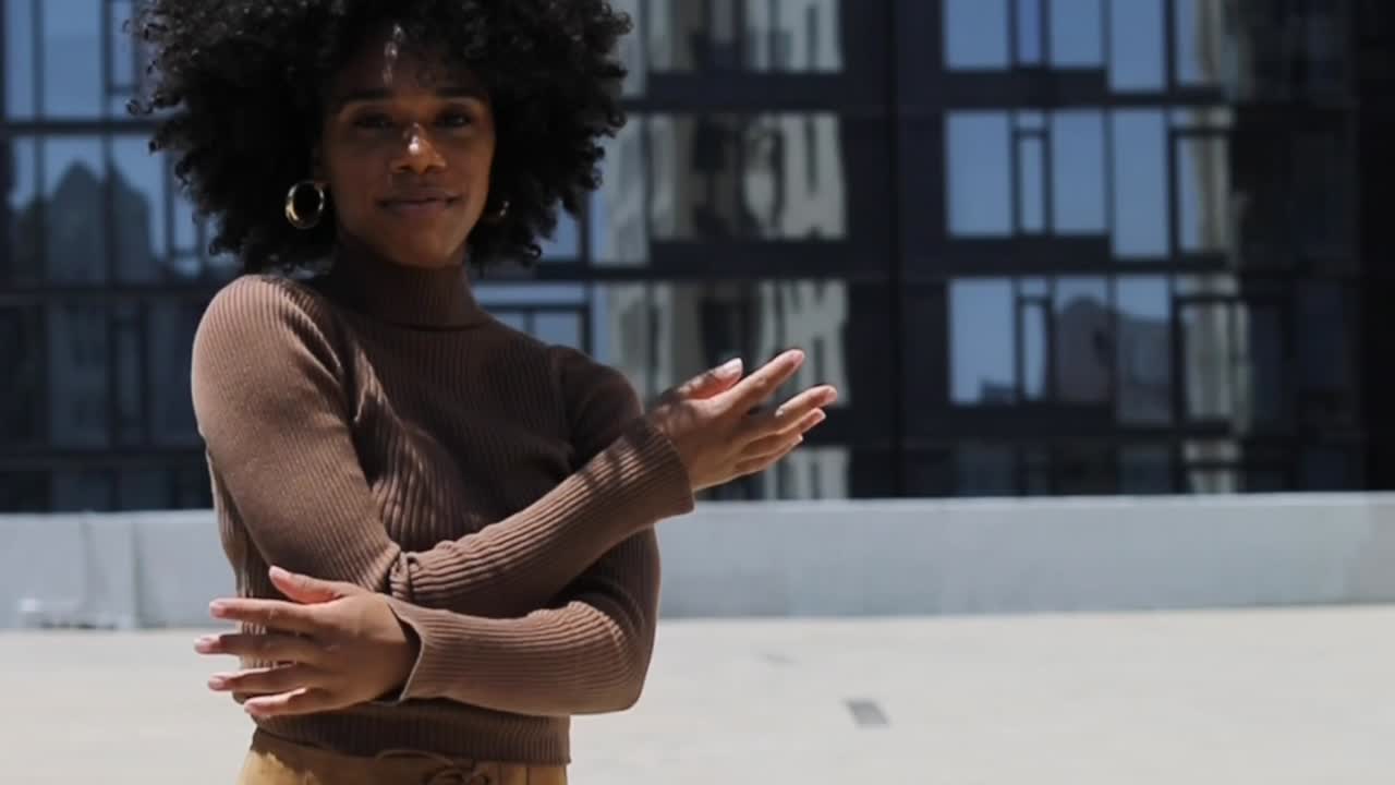 beautiful african american dancer on rooftop in los angeles LA california dancing and vibing midday with big curly hair
