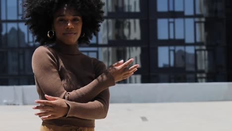 beautiful african american dancer on rooftop in los angeles la california dancing and vibing midday with big curly hair