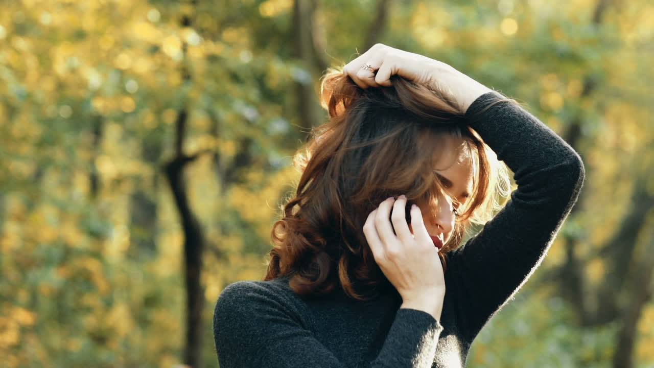 Beautiful female dreaming in the autumn park. Cheerful beautiful girl outdoors on beautiful fall day
