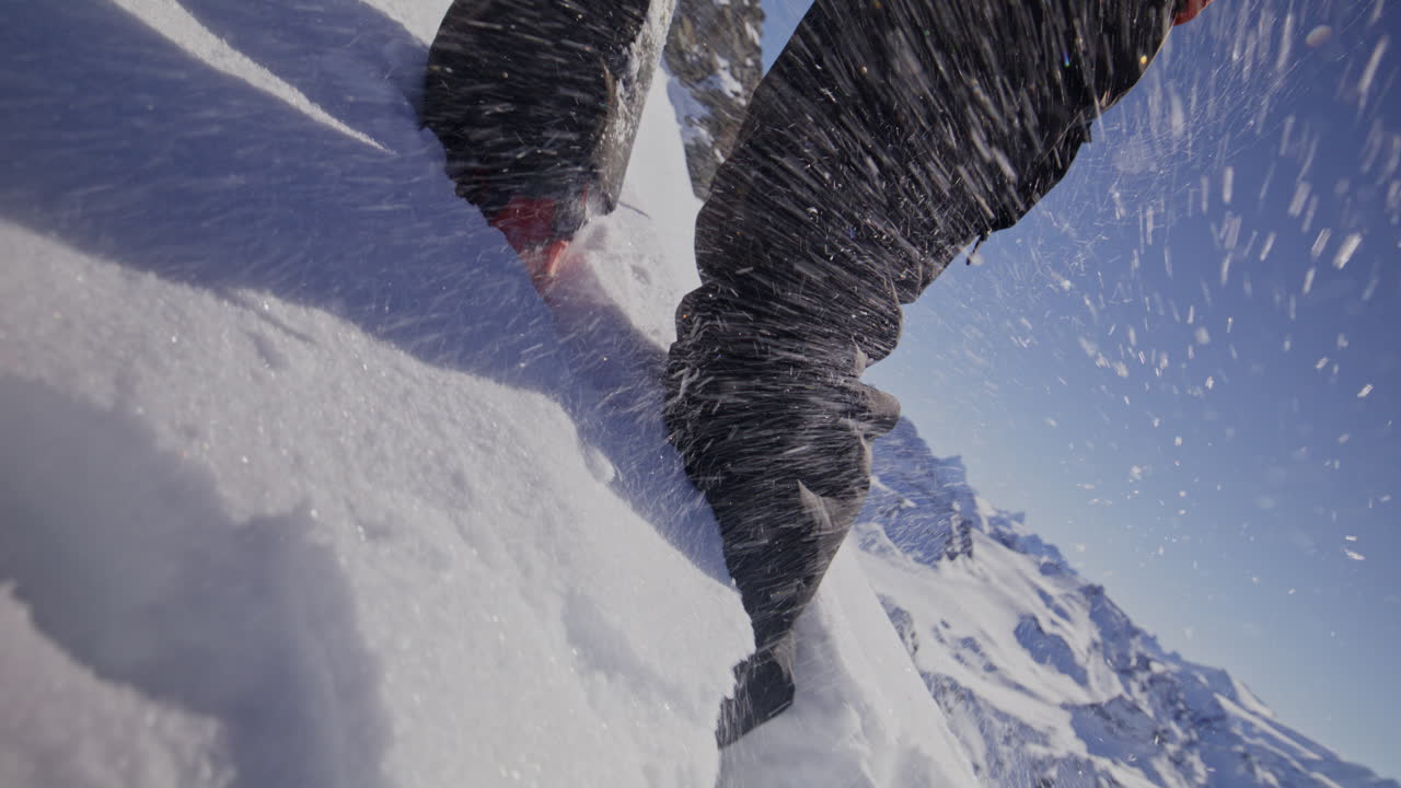 A professional skier hikes up a steep ridge in Verbier, then drops into an epic freeride descent. Pure adventure skiing in deep snow, dramatic terrain, and breathtaking alpine scenery.