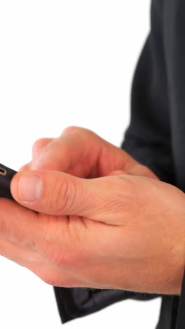 mid section of businessman text messaging on mobile phone