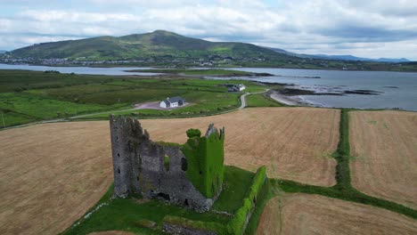 Moosige-Burgruine-Von-Ballycarbery-Mit-Der-Insel-Foughil-Und-Dem-Dorf-Cahirciveen-Im-Hintergrund