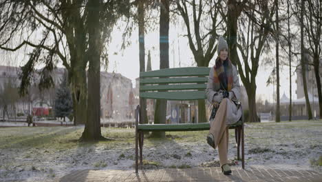 woman sitting on a park bench in winter