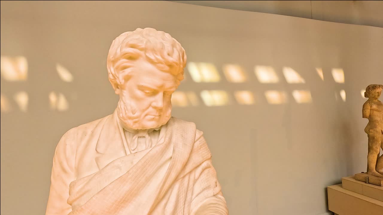 방문객 들 은 빛 이 비치는 갤러리 에서 조각품 을 관찰 한다