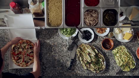 Cook-preparing-pizza-for-delivery-on-kitchen