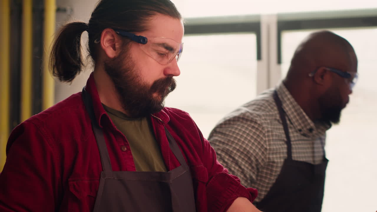 carpintero poniéndose gafas de seguridad mientras elige materiales de madera de calidad