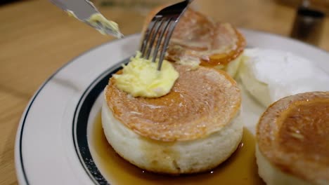 buttering on a fluffy pancakes [top angle