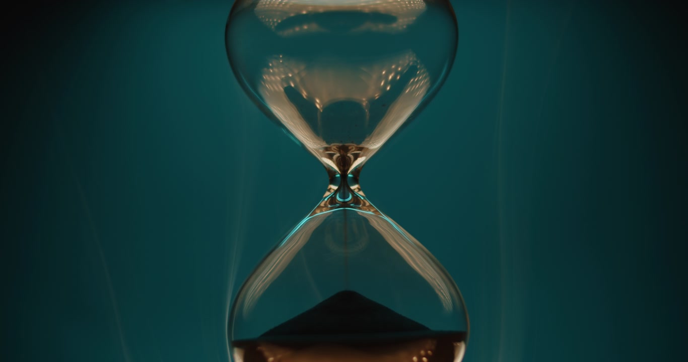 Glossy hourglass on turquoise background