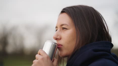 beautiful caucasian female brunette enjoy beverage from aluminium can