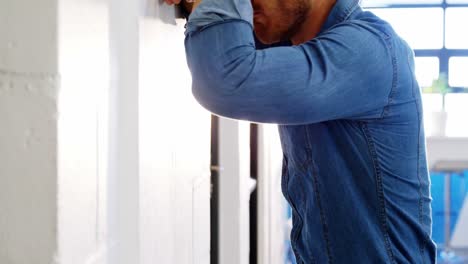 hombre de negocios cansado apoyado en la pared