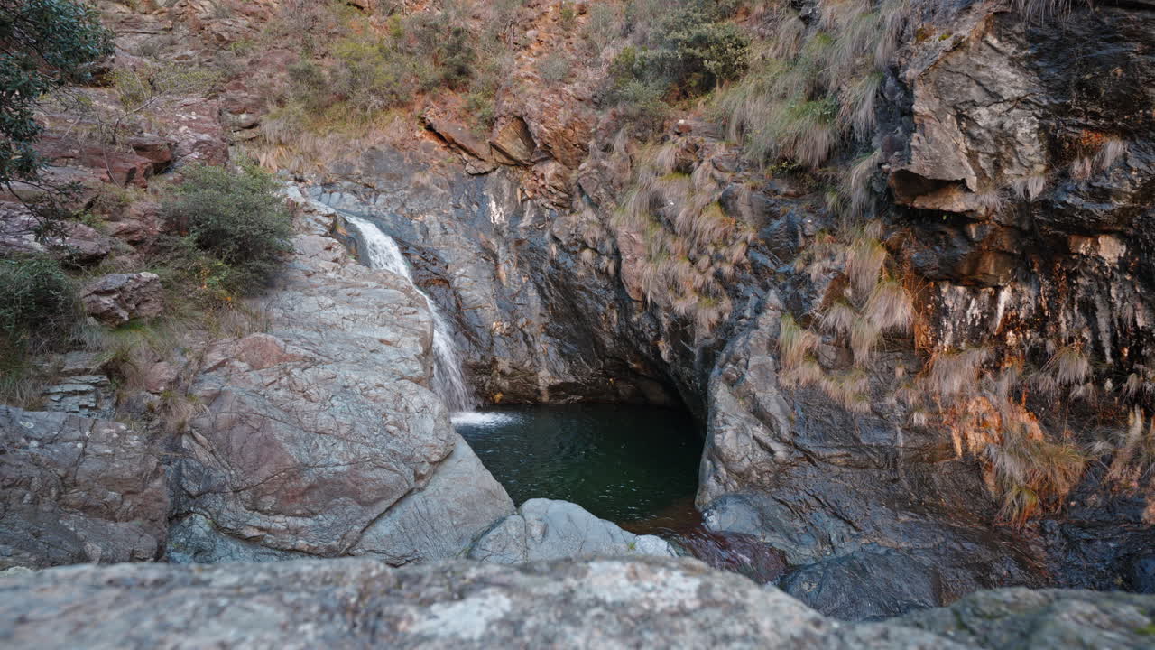 piscina de roca natural aislada con cascada, capturada en la suave luz de la noche