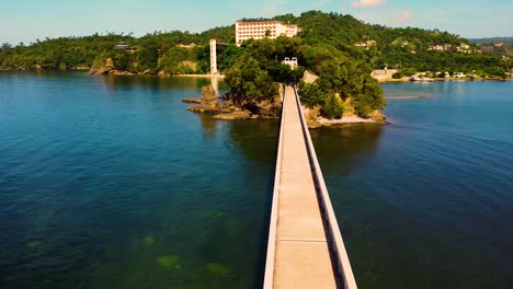 aerial view of a bridge leading to a tropical island resort
