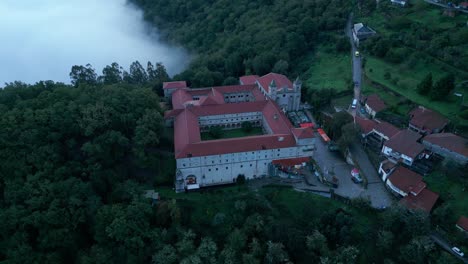 Aerial-Footage-of-Santo-Estevo-Monastery-And-Foggy-Forest,-Luintra,-Spain
