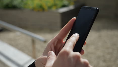 Primer-Plano-De-Manos-De-Hombres-Jóvenes-Caucásicos-Enviando-Mensajes-De-Texto-Por-Teléfono-Afuera