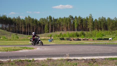 Motorradfahrer-Verlangsamt-Das-Drehen-Und-Untersuchen-Der-Rennstrecke,-Handheld-Ansicht