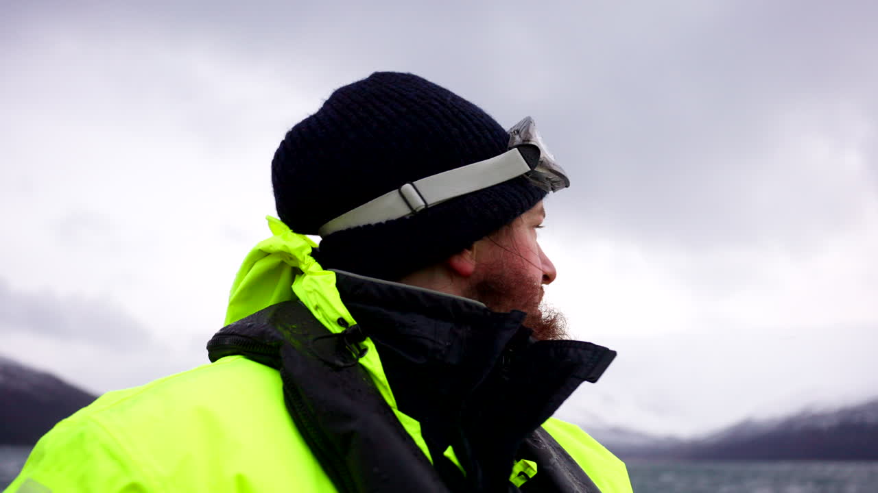 hombre observador de ballenas, ropa de alta visibilidad, excursión noruega