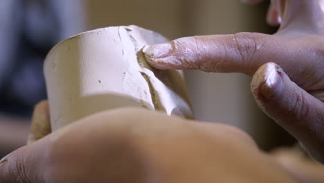 hands shaping a clay vessel