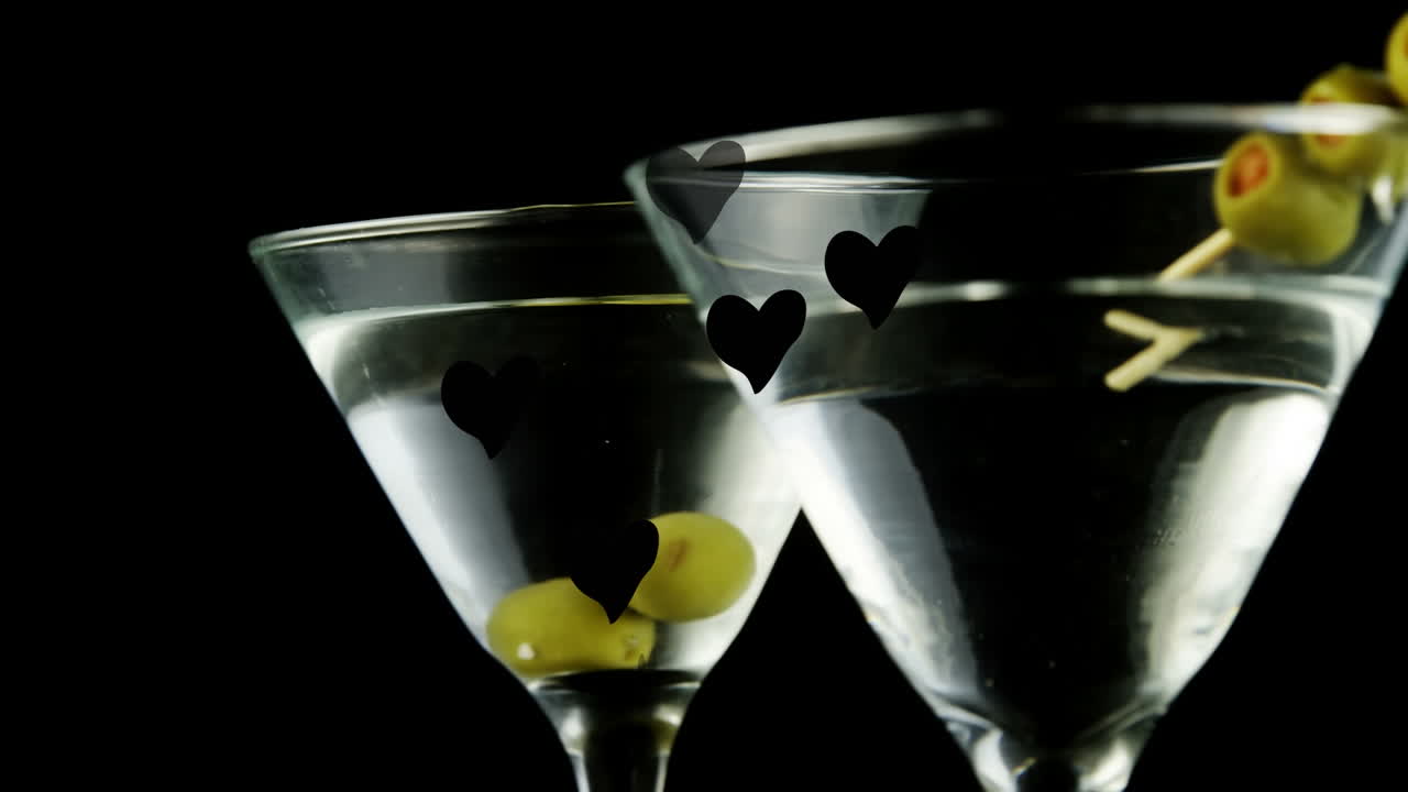 animación de corazones flotando sobre vasos de martini sobre un fondo negro