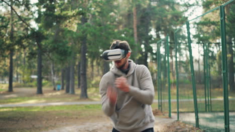 man wearing vr headset boxing in a park