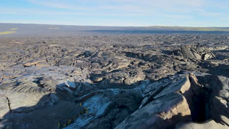 Disparo-Dinámico-De-Un-Dron-Que-Comienza-Desde-Un-Ascenso-Bajo-Y-Rápido-Para-Revelar-El-Extenso-Campo-De-Lava-Que-Domina-El-Paisaje-De-Big-Island,-Hawaii.