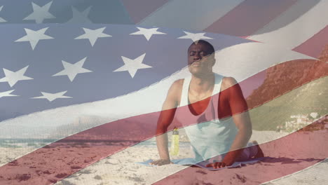 animación de la bandera de los estados unidos de américa sobre un hombre afroamericano practicando yoga en la playa