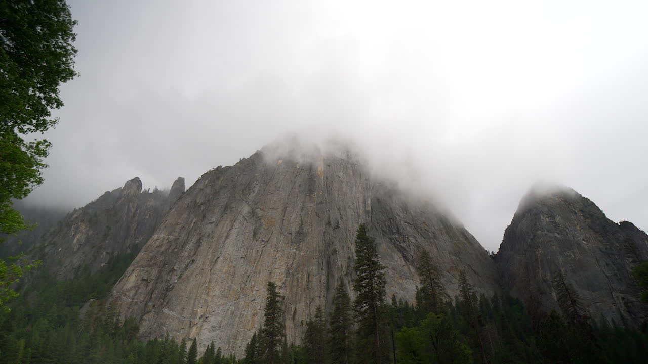 mirando hacia la cara de una montaña en un nublado en el valle de yosemite