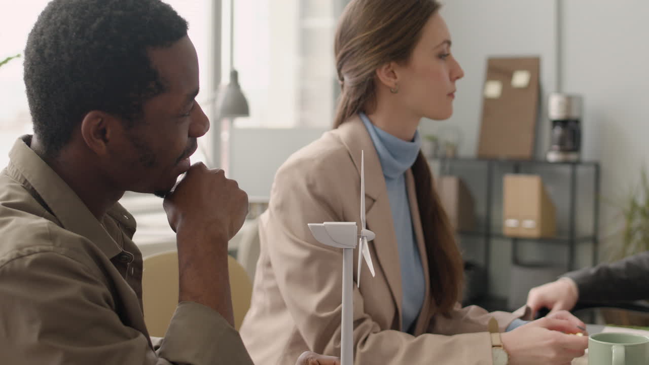 equipo de negocios multiétnico discutiendo sobre el proyecto de energía eólica en la oficina 4