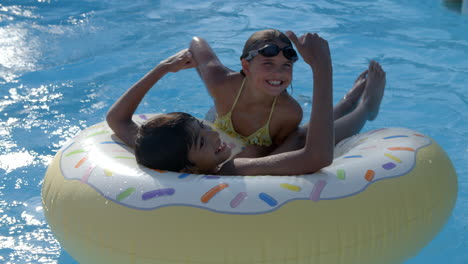 Children-Having-Fun-With-Inflatable-In-Outdoor-Swimming-Pool