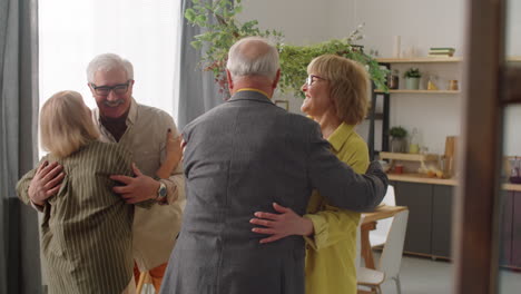 happy senior couple greeting guests at home