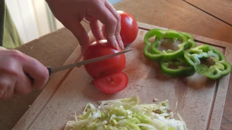 cocinar cortando y rebanando un tomate rojo con verduras en cámara lenta de 4k