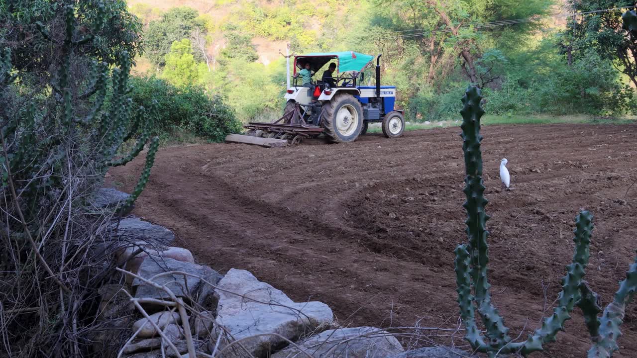 Farmer Plowing Field with Tractor in Rural India
