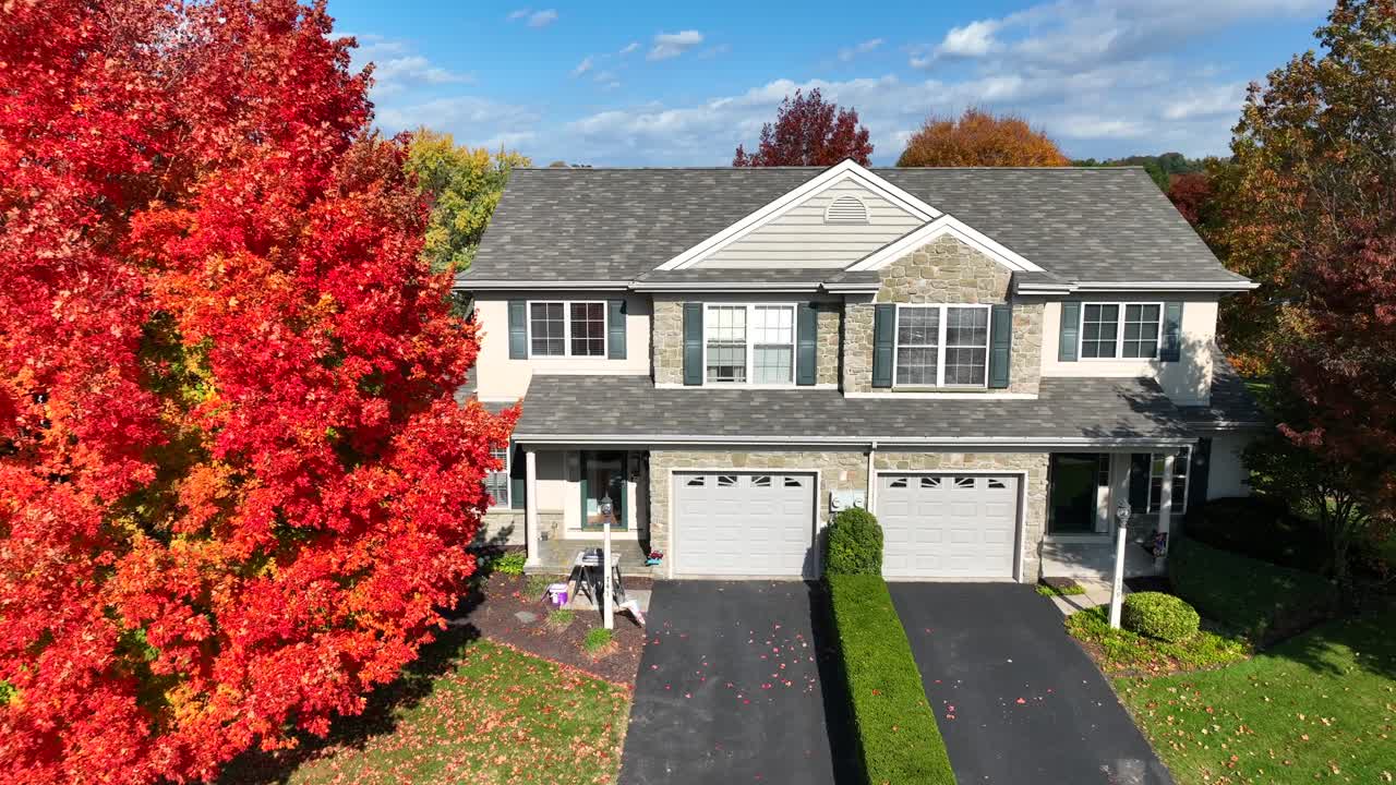 American home with bright red tree in autumn