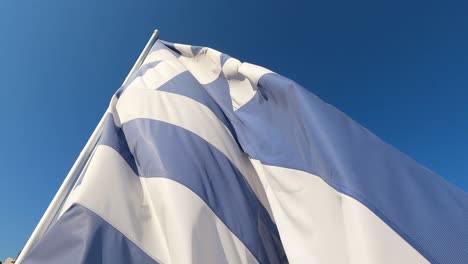 Griechische-Flagge-Weht-Gegen-Den-Sonnigen-Blauen-Himmel