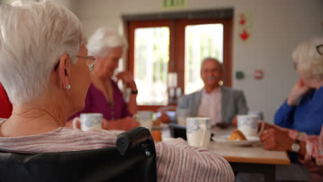 group of mixed-race senior friends eating breakfast on dining table 4k