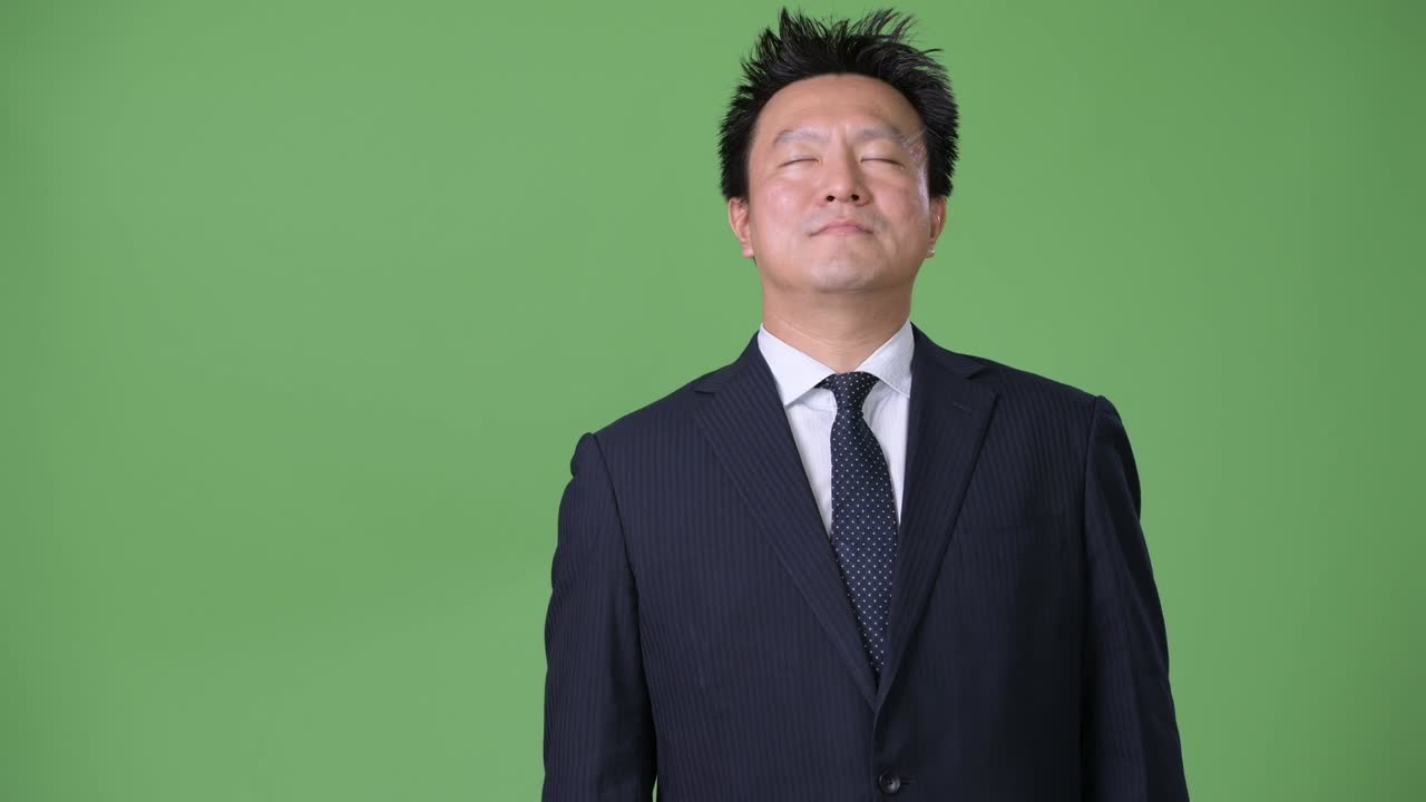 녹색 배경에 성숙한 일본 사업가