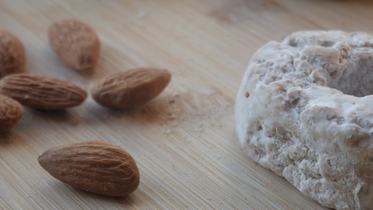 polvorón tradicional español dulce con almendras en una superficie de madera, toma de primer plano