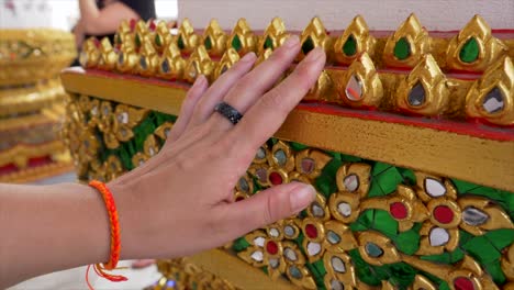 slow motion shot of hand touching the golden decorations of wat pho temple. close-ups of intricate details. perfect for travel, cultural, and religious themed projects.