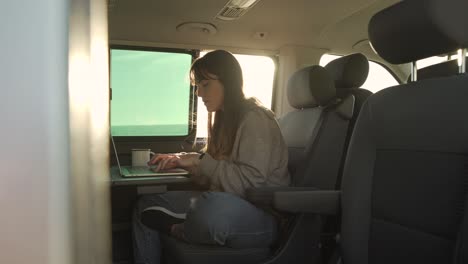 Traveling-woman-working-on-laptop-in-van