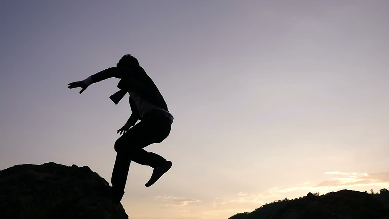 Businessman Overcoming Obstacles at Sunset