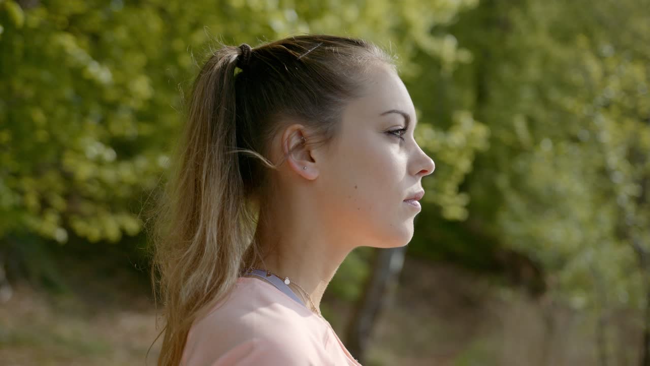 mujer de pie mirando el lago bebiendo agua de la botella