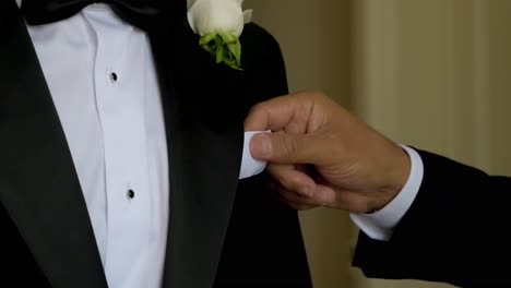 slow motion shot of a best man adjusting a pocket square on the groom